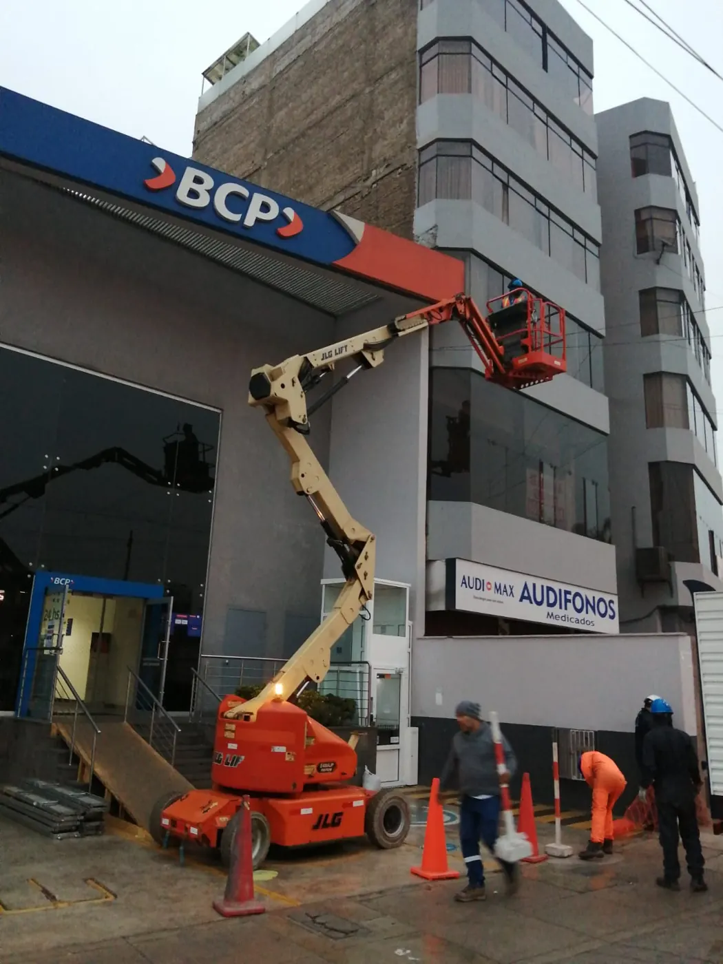 Manlift de brazo articulado trabajando en la fachada del BCP Óvalo Higuereta